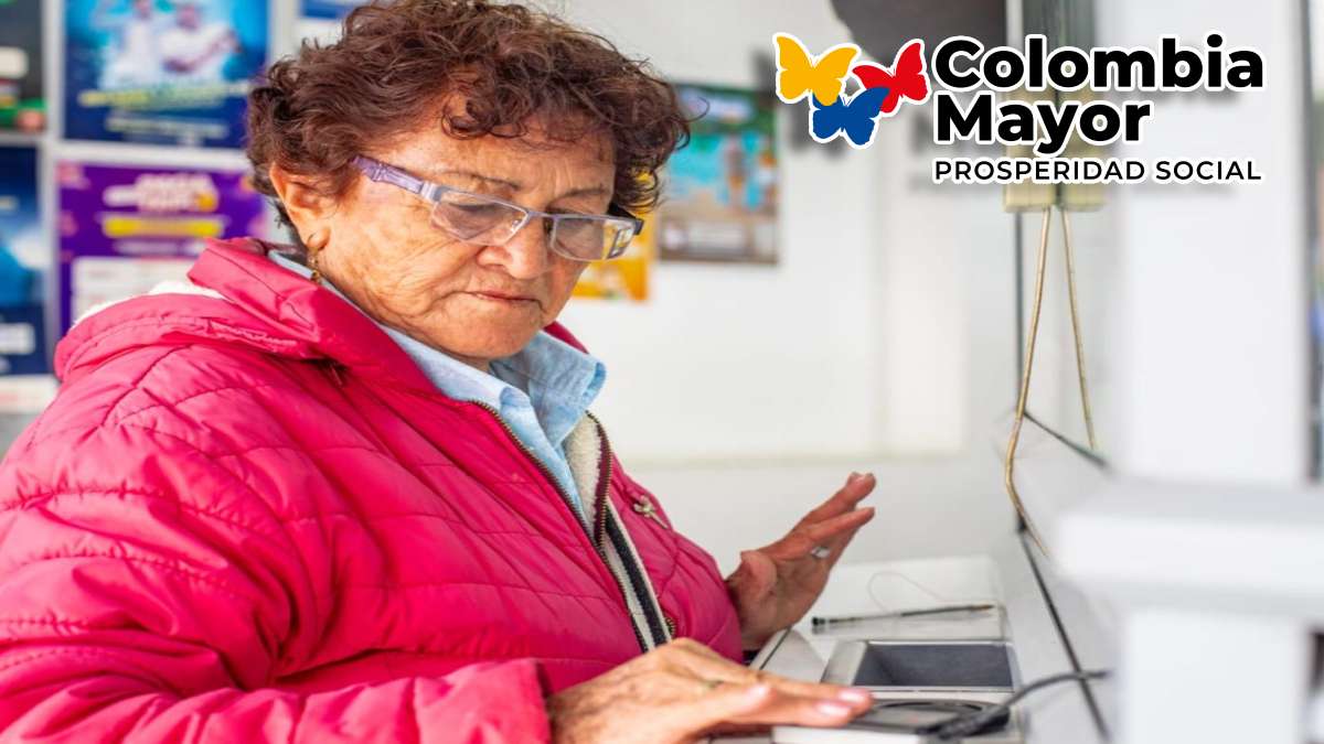 Inician Pagos-MP Noticias, adulta mayor consultando su huella digital en punto de pago, logo de Colombia mayor